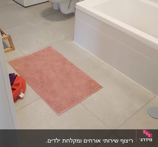 חדר אמבטיה עם רצפת אריחים חדשה ושירותים מותקנים